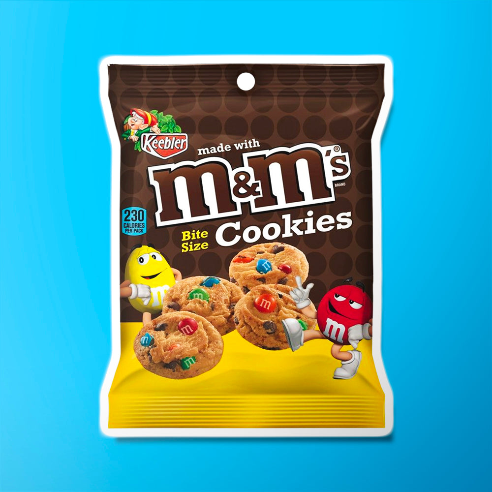 Un paquet marron en haut et jaune en bas avec 4 cookies nature aux pépites de m&m’s jaune, rouge, vert, bleu et marron. Le tout sur fond bleu