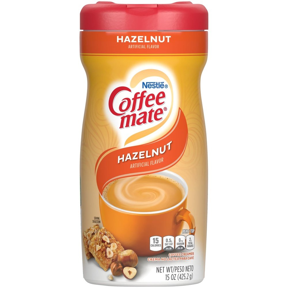 Un paquet orangé sur fond blanc avec un capuchon rouge et une tasse orange avec une une boisson couleur crème