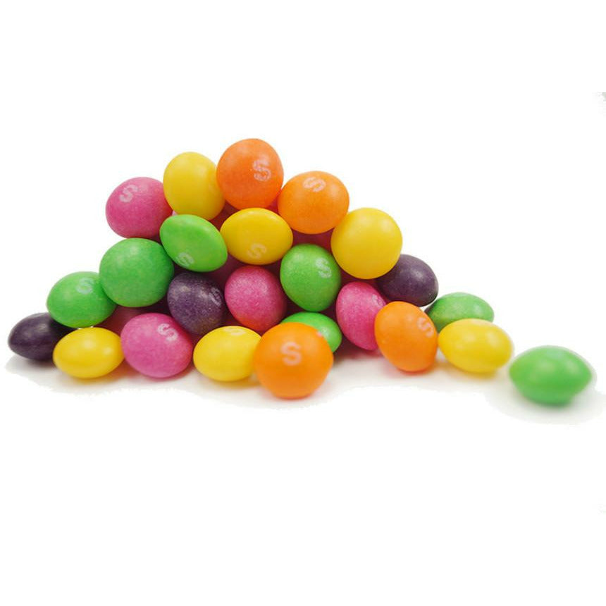 Un petit tas de Skittles sur fond blanc