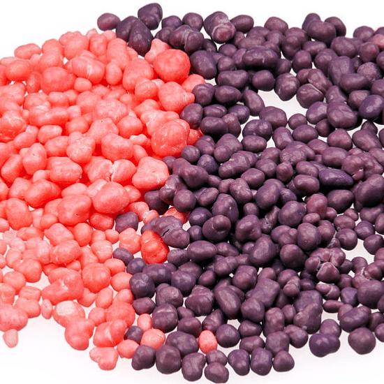 Un tas de petites boules sur fond blanc, roses à gauche et mauves à droite