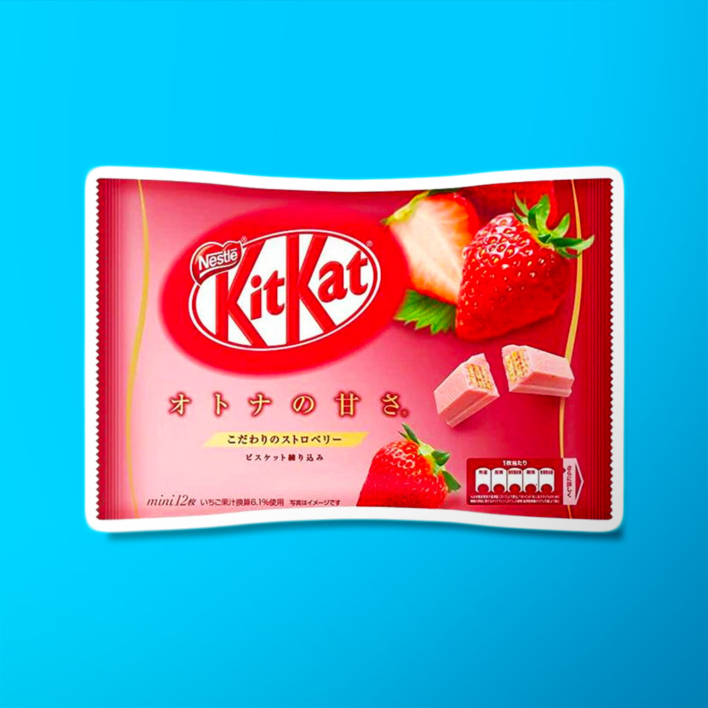 Un grand paquet rouge/rose avec en haut à droite 2 fraises et en bas un biscuit enrobé de chocolat rose. Le tout sur fond bleu