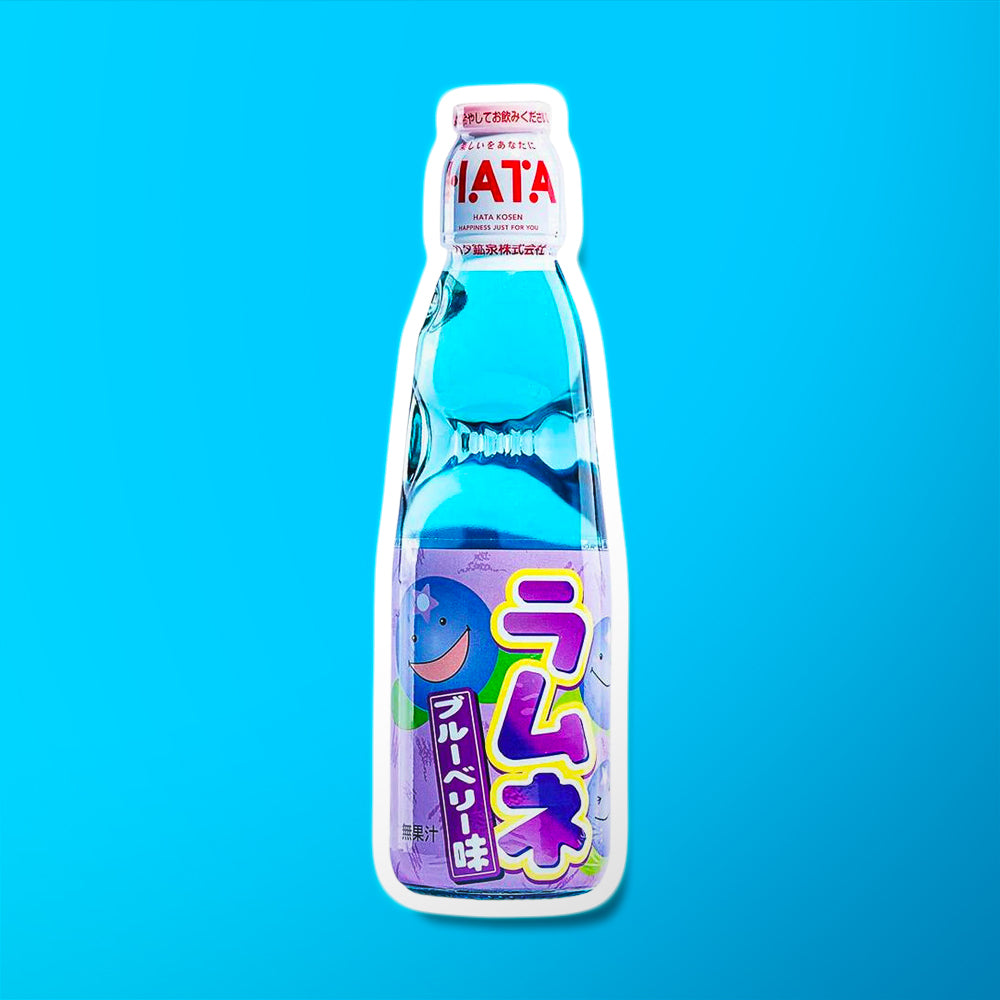 Une bouteille transparente sur fond bleu avec une boisson bleu, il y a une étiquette mauve sur la moitié basse de la bouteille. Il y a des myrtilles qui sourient
