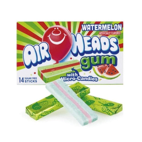 Un paquet rouge-vert sur fond blanc avec un ballon rouge qui sourit et il y a un chewing-gum rouge/vert et à droite 2 morceaux de pastèque. Devant il y a 3 bonbons rouge et vert dont un déballé