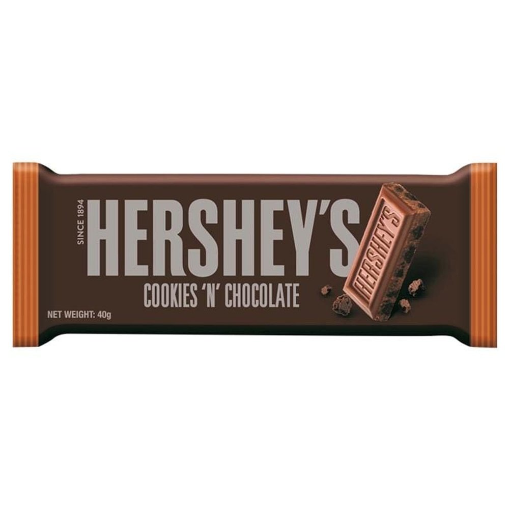 Un emballage brun sur fond blanc et à droite un carré de chocolat avec des pépites de chocolat noir