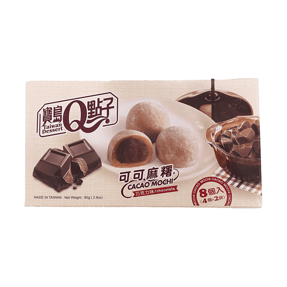 Un paquet beige sur fond blanc avec une assiette blanche avec 3 mochis bruns, à gauche il y a 2 morceaux de chocolat et à droite du coulis de chocolat qui vient d’en haut