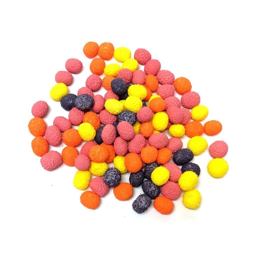 Un tas de bonbons jaune, orange, rose et mauve en forme de boules sur un fond blanc